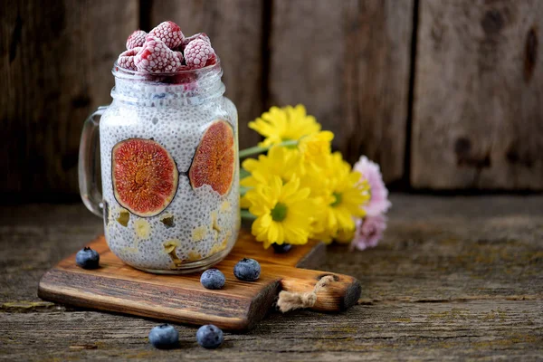 El desayuno saludable es pudín con semillas de chía, jarabe de agave, leche, higos y bayas congeladas de frambuesas y arándanos. Copiar espacio . — Foto de Stock