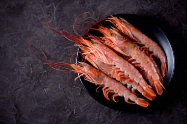 Siyah siyah plaka üzerinde ham taze karides arka plan yandı. Üstten Görünüm