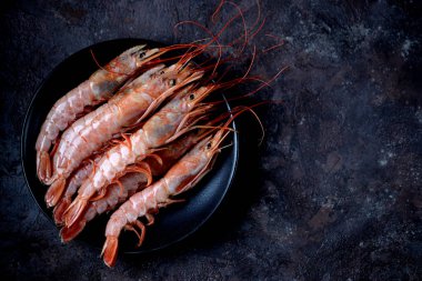 Siyah siyah plaka üzerinde ham taze karides arka plan yandı. Üstten Görünüm