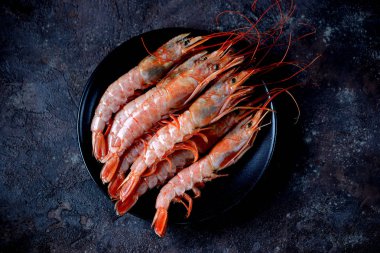 Siyah siyah plaka üzerinde ham taze karides arka plan yandı. Üstten Görünüm