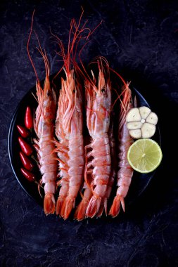 Siyah siyah plaka üzerinde ham taze karides arka plan yandı. Üstten Görünüm