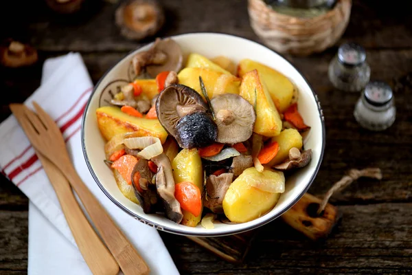 Kartoffelkompott mit Zwiebeln, Pilzen, Karotten, Rosmarin und Knoblauch in Olivenöl. — Stockfoto