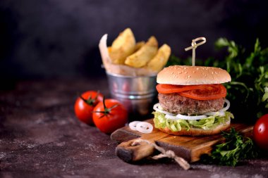 Ev yapımı sığır eti burger organik marul, soğan, domates ve patates kızartması ile.