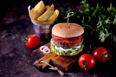 Ev yapımı sığır eti burger organik marul, soğan, domates ve patates kızartması ile.