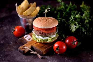 Ev yapımı sığır eti burger organik marul, soğan, domates ve patates kızartması ile.