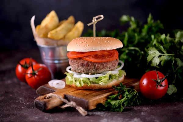 Ev yapımı sığır eti burger organik marul, soğan, domates ve patates kızartması ile.