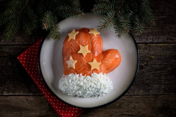 Salat "santa claus mitten" aus gesalzenem Lachs, Salzkartoffeln, Käse, Eiern und Krabbenfleisch. — Stockfoto