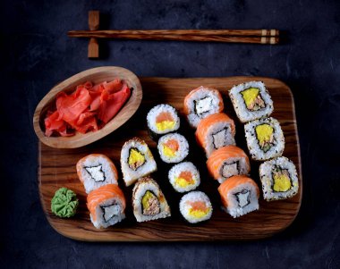 Suşi wasabi ve siyah bir beton zemin üzerine zeytin panosunda Marine zencefil ile.