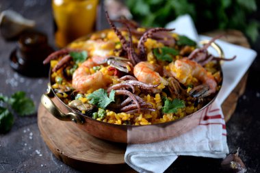 Deniz ürünleri kalamar, karides, midye pirinç, yeşil bezelye, acı biber, safran, zencefil ve Salantro ile.