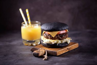 Sığır eti, buzdağı salatası, dilim domates ve kızarmış ekmek peynir ile sağlıklı siyah burger. Sağlıklı gıda.