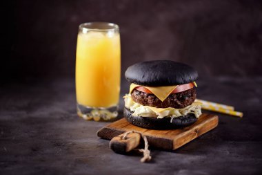 Sığır eti, buzdağı salatası, dilim domates ve kızarmış ekmek peynir ile sağlıklı siyah burger. Sağlıklı gıda.