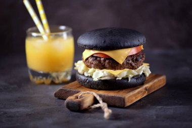 Sığır eti, buzdağı salatası, dilim domates ve kızarmış ekmek peynir ile sağlıklı siyah burger. Sağlıklı gıda.