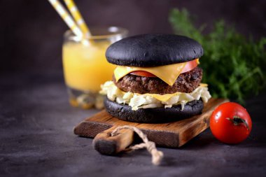 Sığır eti, buzdağı salatası, dilim domates ve kızarmış ekmek peynir ile sağlıklı siyah burger. Sağlıklı gıda.