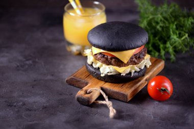 Sığır eti, buzdağı salatası, dilim domates ve kızarmış ekmek peynir ile sağlıklı siyah burger. Sağlıklı gıda.