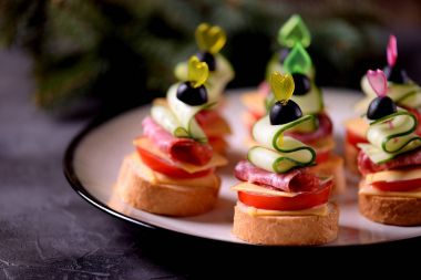 Canap şiş ekmeği baget ekmek peynir, sosis, domates, salatalık ve zeytin ile gelen üzerinde. Yeni yıl için geleneksel snack.