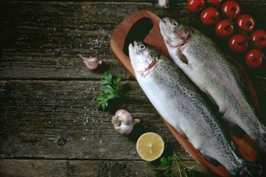 Eski bir ahşap zemin üzerinde organik çiğ taze alabalık balık. Üstten Görünüm.