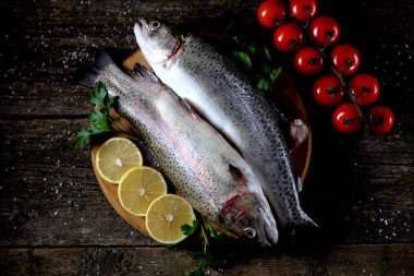 Eski bir ahşap zemin üzerinde organik çiğ taze alabalık balık. Üstten Görünüm.