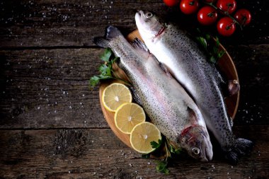 Eski bir ahşap zemin üzerinde organik çiğ taze alabalık balık. Üstten Görünüm.