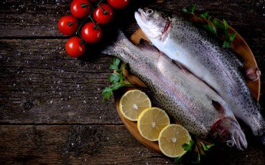 Eski bir ahşap zemin üzerinde organik çiğ taze alabalık balık. Üstten Görünüm.