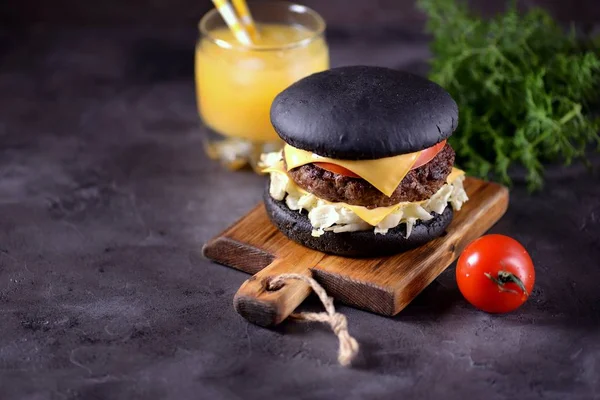 Sığır eti, buzdağı salatası, dilim domates ve kızarmış ekmek peynir ile sağlıklı siyah burger. Sağlıklı gıda.