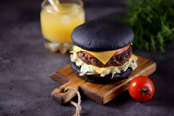 Sığır eti, buzdağı salatası, dilim domates ve kızarmış ekmek peynir ile sağlıklı siyah burger. Sağlıklı gıda.