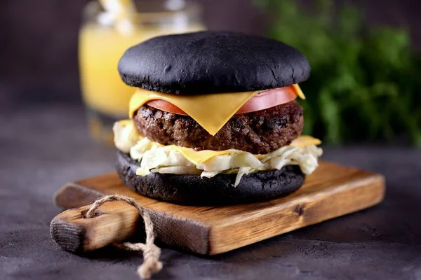 Sığır eti, buzdağı salatası, dilim domates ve kızarmış ekmek peynir ile sağlıklı siyah burger. Sağlıklı gıda.