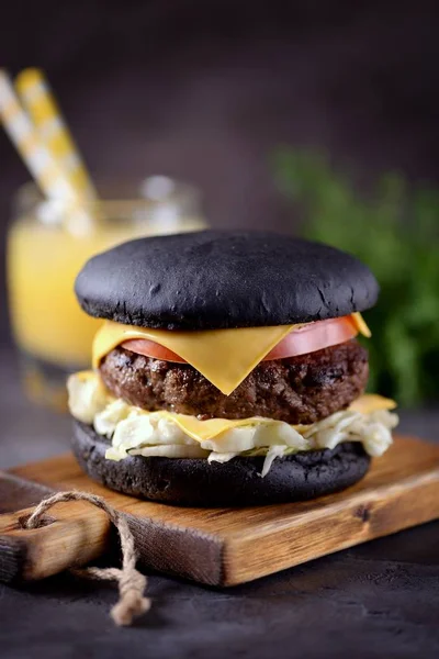 Sığır eti, buzdağı salatası, dilim domates ve kızarmış ekmek peynir ile sağlıklı siyah burger. Sağlıklı gıda.