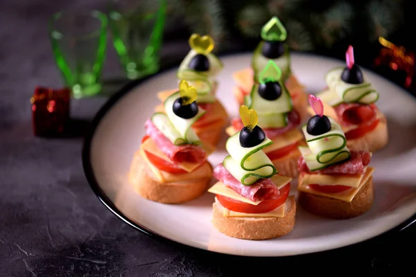 Canap şiş ekmeği baget ekmek peynir, sosis, domates, salatalık ve zeytin ile gelen üzerinde. Yeni yıl için geleneksel snack.
