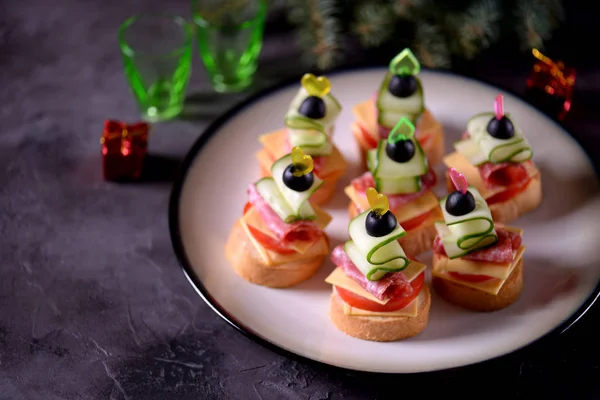 Canap şiş ekmeği baget ekmek peynir, sosis, domates, salatalık ve zeytin ile gelen üzerinde. Yeni yıl için geleneksel snack.