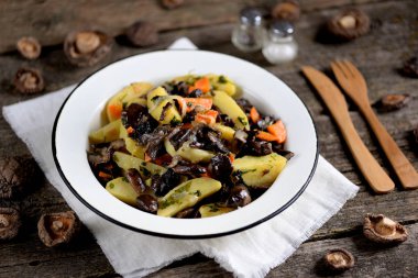 Haşlanmış patates soğan, havuç ve eski bir ahşap zemin üzerinde orman meyveleri ile.