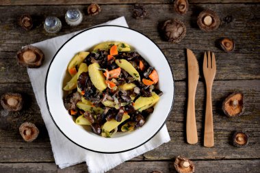 Haşlanmış patates soğan, havuç ve eski bir ahşap zemin üzerinde orman meyveleri ile.