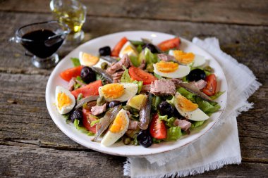 Ton balığı, haşlanmış patates, yumurta, yeşil fasulye, domates, Sele zeytin, marul ve hamsi ile Fransız salatası salata.