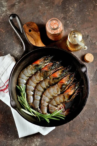 Raw fresh tiger shrimps with fresh rosemary and pink salt. Healthy sea food.