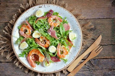 Sağlıklı salata karides, roka, Parma jambonu, bıldırcın yumurtası ve parmesan peyniri ile.