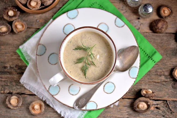 古い木製の背景の上にカップの新鮮で乾燥茸おいしい健康的なスープ — ストック写真