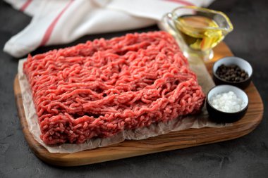 Kıyılmış sığır eti üzerinde siyah bir arka plan ile deniz tuzu, karabiber.