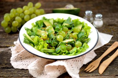 Avokado, salatalık, üzüm, maydanoz ve marul zeytin ile sağlıklı yeşil salata sos, balsamik sirke ve tahıl hardal yağı.