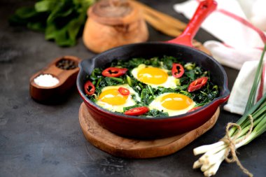 Ispanak, yeşil soğan, kişniş, maydanoz, chilipertsem ve zeytin yağı ile sağlıklı yeşil shakshuka. Sağlıklı gıda.