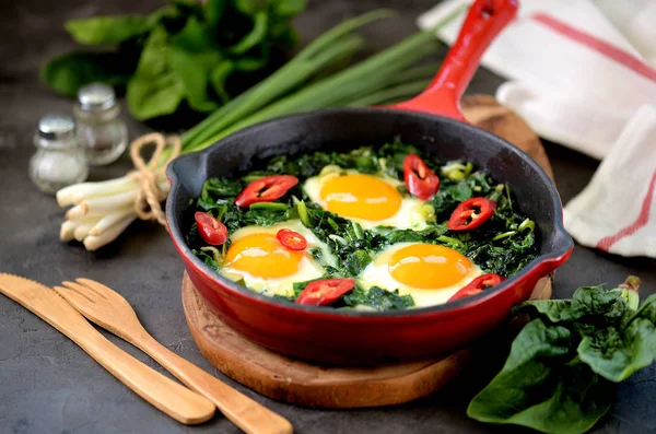 Healthy green shakshuka with spinach, green onion, cilantro, parsley, chilipertsem and olive oil. Healthy food.