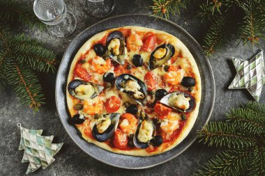 Deniz mahsullü nefis ev yapımı pizza. Kabuklu midye, karides kuyruğu, kapari ve zeytin. Noel arkaplanı.