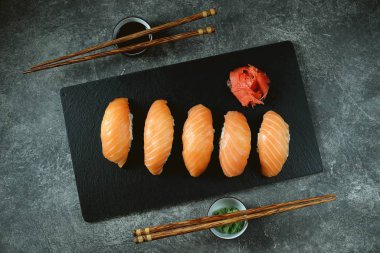 Siyah servis panosunda somonlu Nigiri suşisi. Üst görünüm. 