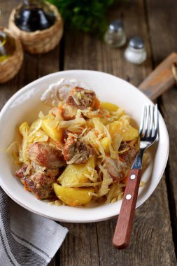 Lahana, havuç, soğan, domates sosu ve domuz pirzolası ile haşlanmış patates..