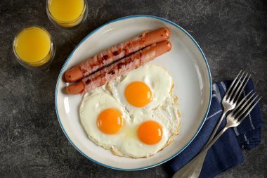 Domuz pastırması ve portakal suyuyla sahanda yumurta. Geleneksel samimi kahvaltı..