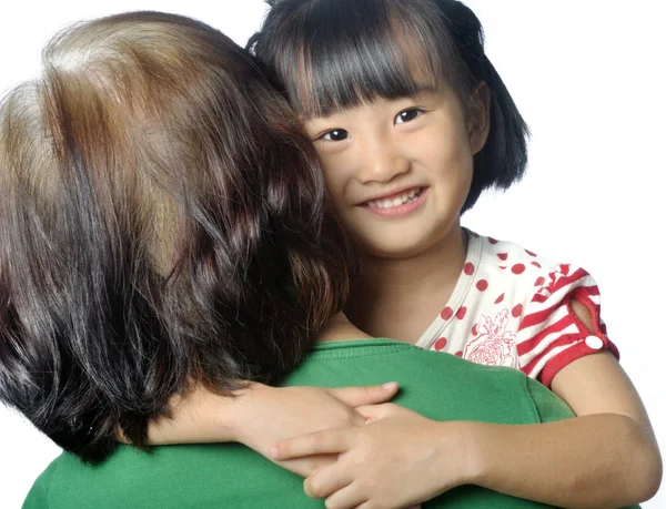 Little asian granddaughter smiling in senior woman's arm — Stock Photo, Image