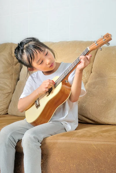 Asiática niña jugando ukelele — Foto de Stock