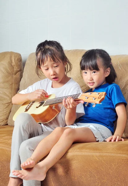 Dos asiático pequeño chica jugando ukelele y cantando juntos — Foto de Stock