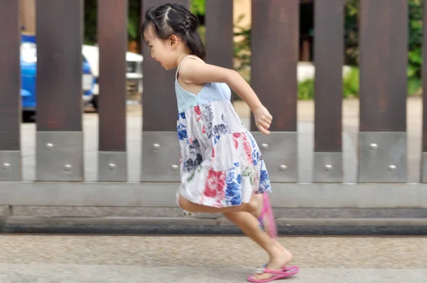 Маленька азіатська дитина біжить на відкритому повітрі, стріляючи з розмиттям руху — стокове фото