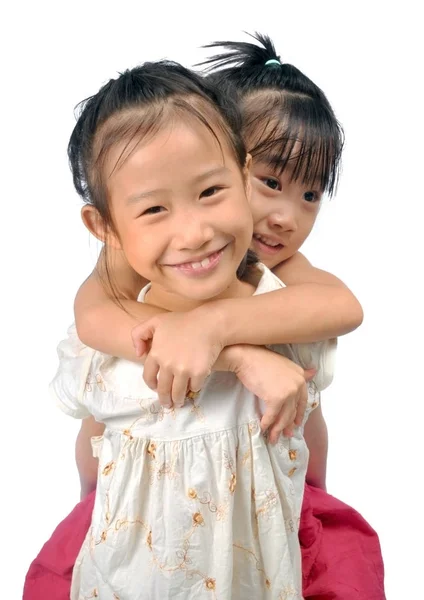 Asian little girl carries her sister on her back — Stock Photo, Image