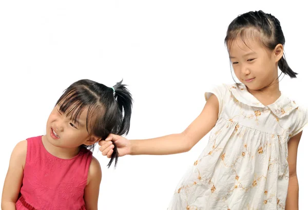 Siblings teasing, asian little girl pulling her sister's hair — Stock Photo, Image