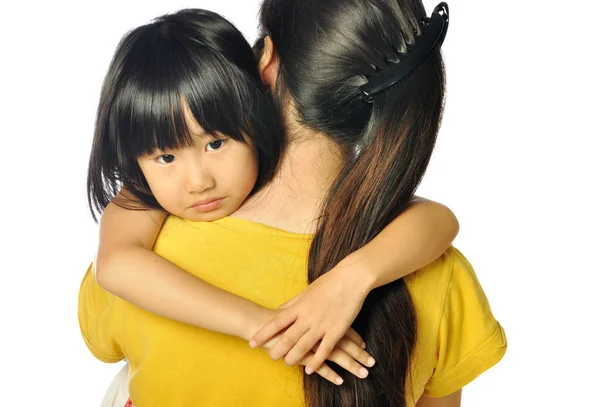 Sad asian little girl hugging parent around shoulders — Stock Photo, Image